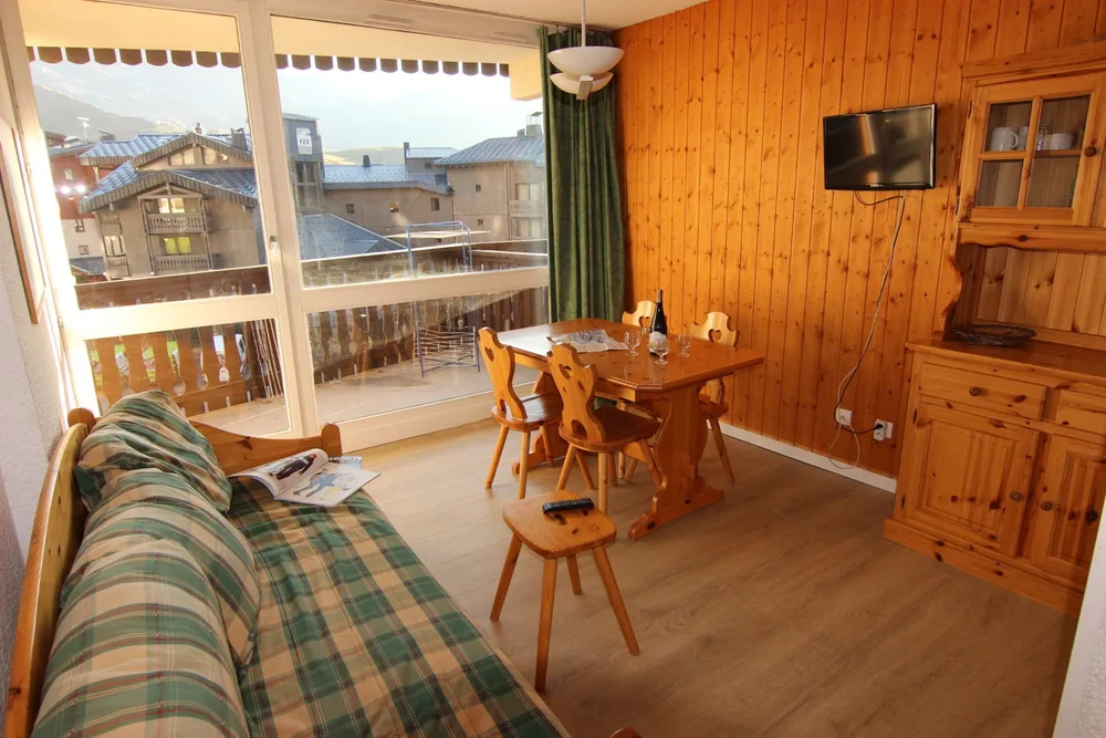 Svijetli dnevni boravak s blagovaonskim stolom i izlazom na balkon, studio Lac du Lou 110 u Val Thorensu
