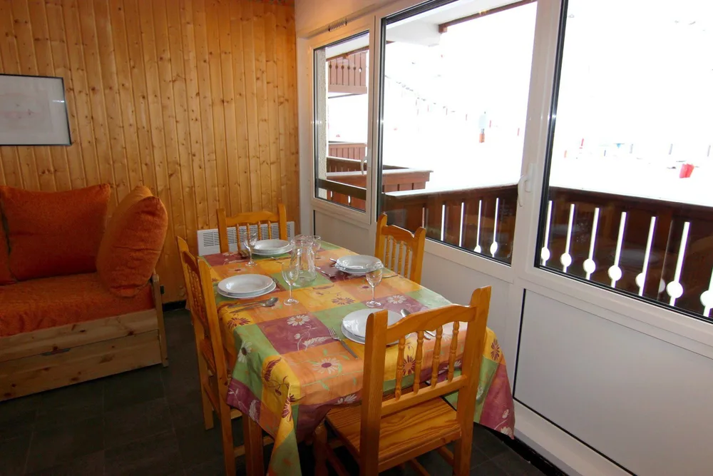 Blagovaonica uz ostakljeni balkon s pogledom na staze, apartman Olympic 504
