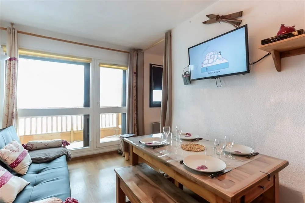 Dnevni boravak s kaučem, TV-om, blagovaonskim stolom i izlazom na balkon prema jugu, apartman Vanoise 260