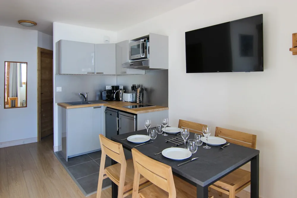 Kuhinja s indukcijskom pločom i perilicom posuđa te blagovaonski stol, apartman Zénith 27